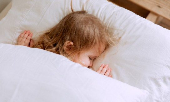 photo of child laying on bed 3933069
