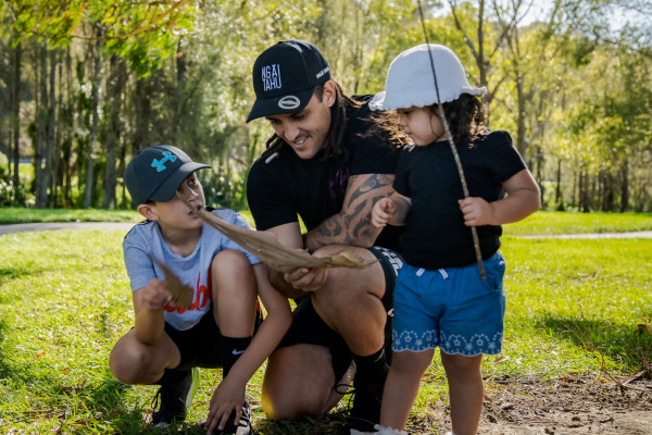 Dad playing outside with his two kids.