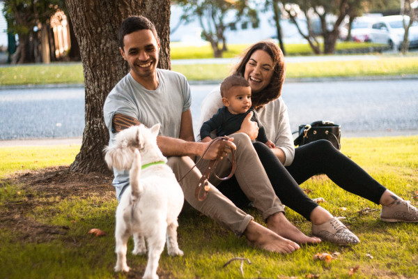 Family sitting outside with dog.