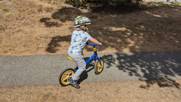 A young boy wearing a helmet riding a bike.