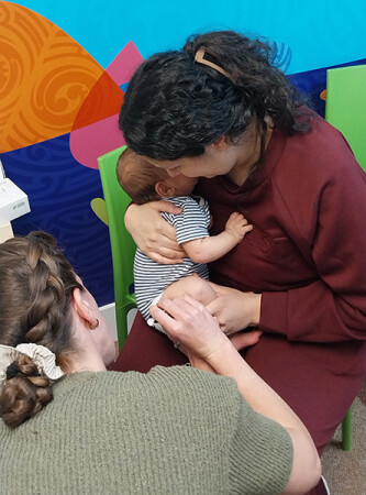 Plunket nurse vaccinating a baby held by its mother at Dunedin immunisation clinic