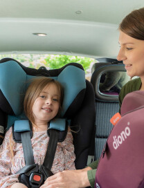 Mum adjusting straps of forward facing car seat