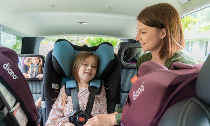 Mum adjusting straps of forward facing car seat