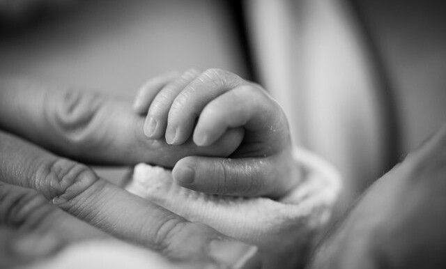 grayscale photography of baby holding finger 208189