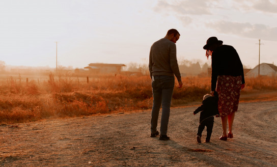 man and woman walking with there kid on dirt road 3285036