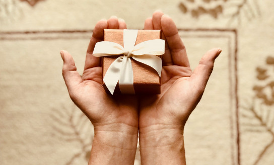 person s holds brown gift box 842876