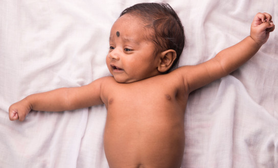 topless baby lying on white bed 3614108